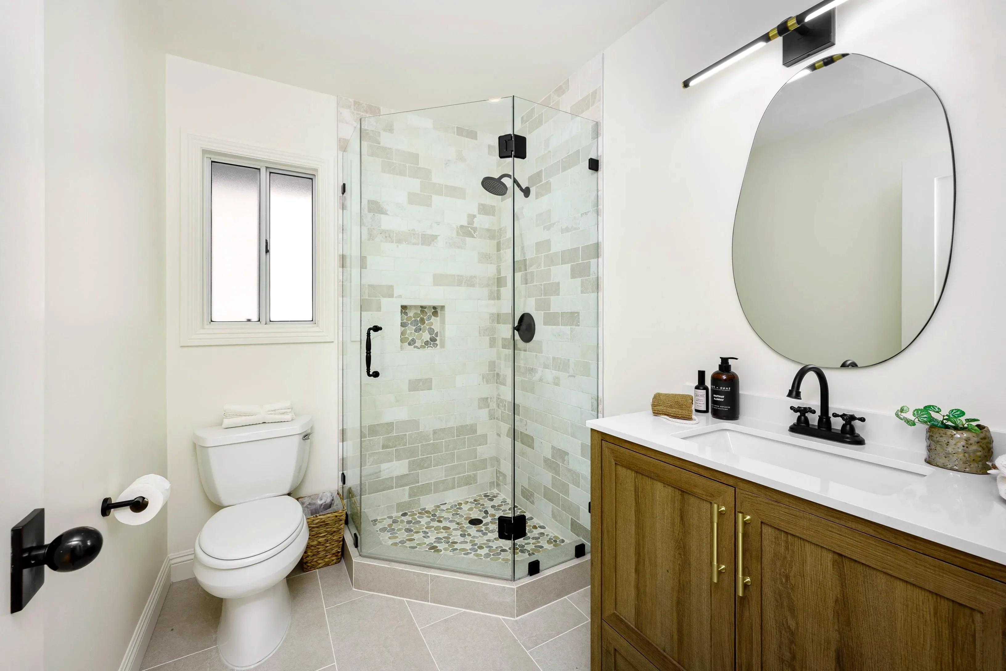 Baño con acabados arena y madera en Cambrils